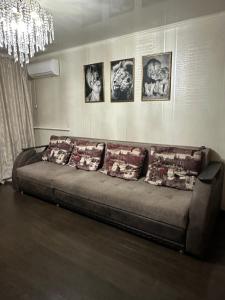 een bank in een woonkamer met foto's aan de muur bij 2 ком люкс в центре города in Karagandy