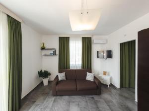 a living room with a brown couch and green curtains at Casa Vacanze Il Vigneto in Marsala