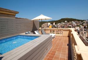 a swimming pool on the roof of a building with an umbrella at Catalonia Majórica in Palma de Mallorca +54 photos