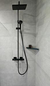 a shower with a shower head in a bathroom at Domek w Lesie z Kominkiem i Ogrodem Niedalino in Niedalino +28 photos