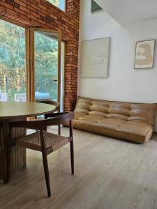 a living room with a couch and a table at Domek w Lesie z Kominkiem i Ogrodem Niedalino in Niedalino