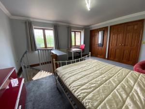 a bedroom with a bed and a desk and windows at Host & Stay - Studley Knapp in Milton Keynes