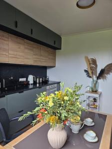 a kitchen with a table with flowers on it at La Maison des Saveurs in Trouville-sur-Mer