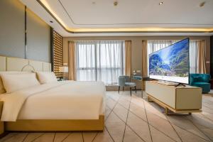 ein Hotelzimmer mit einem Bett und einem Flachbildfernseher in der Unterkunft Atour S Hotel Guangzhou Beijing Road Tianzi Wharf-Free Shuttle Bus From Hotel To Pazhou Exhibition Center During Canton Fair in Guangzhou