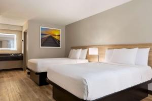 een hotelkamer met twee bedden en een wastafel bij Hotel Barkley in Kuttawa