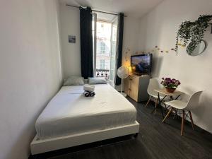 a bedroom with a bed and a table and a tv at Delight room 1st door in Nice