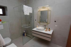 a bathroom with a sink and a glass shower at Lazovic- Apartment by the Sea with Amazing View in Dobrota