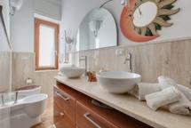 a bathroom with two sinks and a clock on the wall at B&B La Terrazza in Rome +65 photos