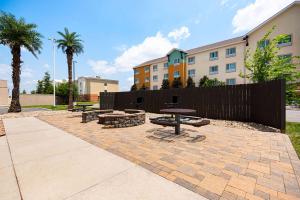 a patio with three picnic tables and a fence at La Quinta by Wyndham Gonzales LA in Gonzales