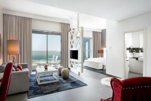 a living room with a bedroom and a living room with a bed at The First Collection Dubai Marina in Dubai
