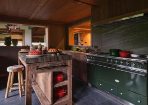 a kitchen with a stove and a counter with a table at Chalet Molitor, avec services, Collection Chalets des Fermes in Megève