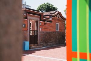 a brick building with a door and a colorful wall at Wuzou Guesthouse in Jinsha