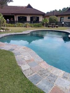 a swimming pool in a yard with a stone path around it at 47 Bondi Beach in Shelly Beach
