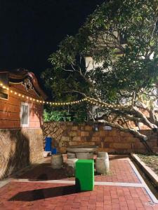 a patio with a bench and a tree with lights at Wuzou Guesthouse in Jinsha