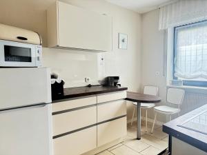 a kitchen with a white refrigerator and a table at Apartments Gala, ruhige Lage, stadtnah in Bad Kissingen