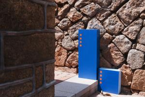 a blue pillar in front of a stone wall at Wuzou Guesthouse in Jinsha