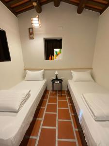 two beds in a room with a table between them at Wuzou Guesthouse in Jinsha