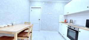 een keuken met een houten tafel en een eetkamer bij Аэропорт 10 минут жк Будапешт163 in Astana