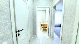 een gang met een deur die naar een eetkamer leidt bij Аэропорт 10 минут жк Будапешт163 in Astana