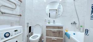 een badkamer met een toilet, een wastafel en een spiegel bij Аэропорт 10 минут жк Будапешт163 in Astana