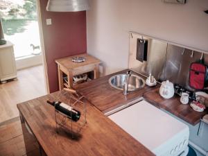 a kitchen with a sink and a wooden counter top at Cottage near the Mill Pond with a beautiful garden in Le Ponchel