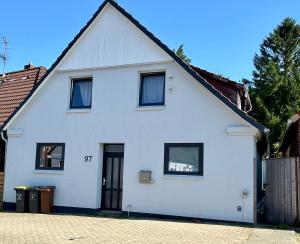 a white house with black windows on a street at Smilla in Bad Segeberg