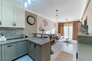a kitchen and living room with a clock on the wall at Luxury Cozy Apartments at Adora Park in Arad