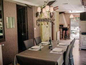 a dining room with a table with chairs and a chandelier at Cottage near the Mill Pond with a beautiful garden in Le Ponchel