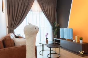 a living room with a white cat statue in front of a television at Mayabay Gamuda Cove SplashMania Suite in Banting +70 photos