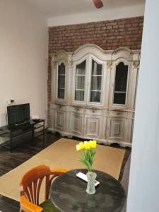 a table with a vase with yellow flowers on it at Golden Age Hollywood PROMO PRICE! in Vračar (historical)