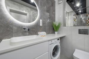 a bathroom with a washing machine and a mirror at Modern Apartment With Private Garden Międzywodzie by Renters Prestige in Międzywodzie +41 photos