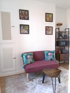 a living room with a purple couch and a table at Appartement au cœur du patrimoine sézannais in Sézanne