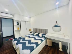 a bedroom with a large bed and a mirror at Cosy homestay and apartment in Hai Phong