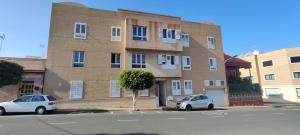 two cars parked in a parking lot in front of a building at Attaday Home Holidays in Ingenio