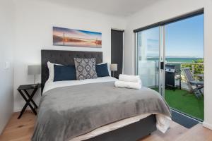 una camera da letto con un letto con vista sull'oceano di 64 Whalerock Estate a Hermanus Altre 13 foto