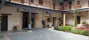 an empty courtyard of a building with plants and flowers at La Casona del Asno in Alcalá de Henares