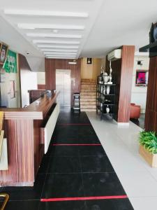 Un vestíbulo con suelo de baldosas negras y un mostrador. en رؤوم إن للشقق المخدومة - Raoum Inn Serviced Apartments-Hotah, en Hotat bani tamim