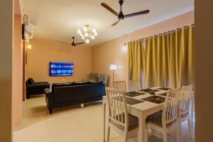a living room with a table and chairs and a couch at Layover Lounge Close to Airport, BITS in Sancoale