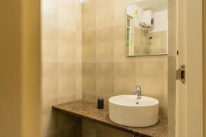 a bathroom with a white sink on a counter at Layover Lounge Close to Airport, BITS in Sancoale +35 photos