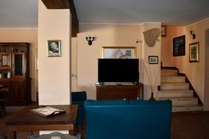 a living room with a television and a staircase at Al Vecchio Camino in Rotonda