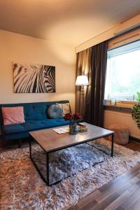 a living room with a blue couch and a table at Family Retreat Near Train and Kuusijärvi Lake in Vantaa