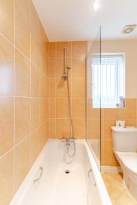 a bathroom with a bath tub and a toilet at 4 Bedroom Detached, Wi-Fi, Parking, stunning views in Newcastle under Lyme +64 photos