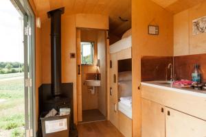a kitchen with a stove in a tiny house at Barbara Shepherds Hut in Kent +13 photos