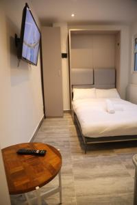 a hotel room with a bed and a table and a tv at Smashing Studio in London