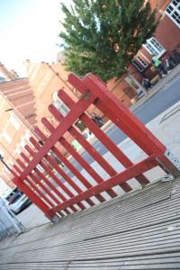 a red bench sitting on top of a sidewalk at Smashing Studio in London