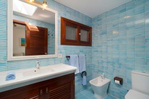 a blue tiled bathroom with a sink and a toilet at Sea Front Caletón Suite in Los Pocillos +26 photos