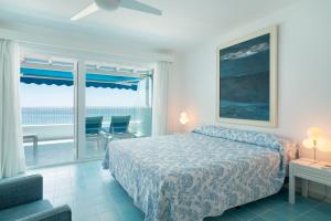 a bedroom with a bed and a view of the ocean at Sea Front Caletón Suite in Los Pocillos