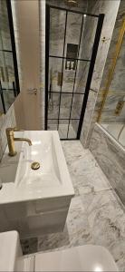 a bathroom with a sink and a toilet and a tub at Stylish new 2 bedroom apartment in London