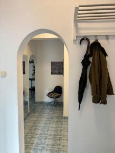 ein Flur mit einem Torbogen mit Regenschirmen an einer Wand in der Unterkunft Airy & Beautiful Downtown Apartment in Bukarest