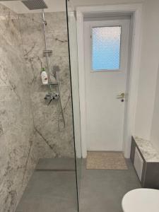 ein Badezimmer mit Dusche und Glastür in der Unterkunft Airy & Beautiful Downtown Apartment in Bukarest + 11 Fotos